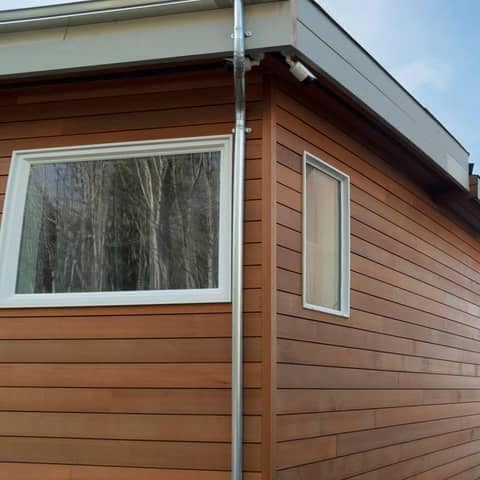 Roofline with a metal gutter run and downspout on a residential exterior