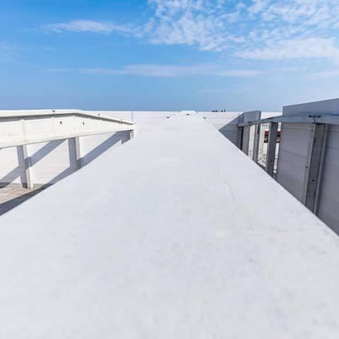 Low-slope roof membrane and parapet under a clear sky